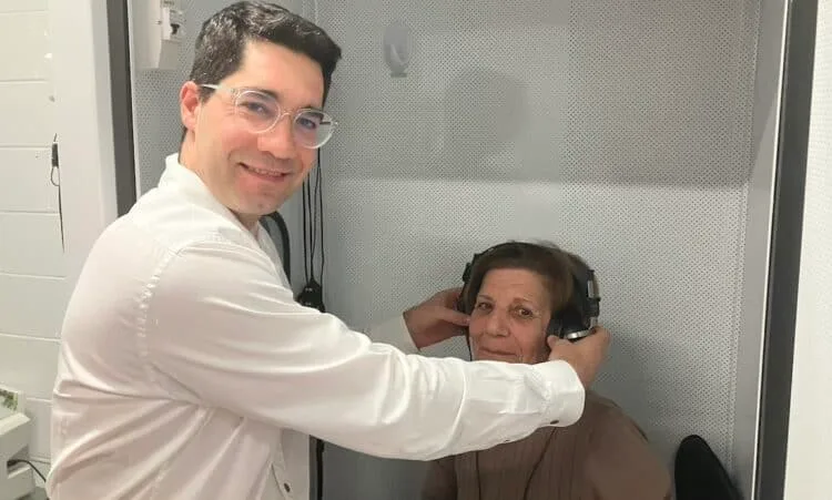 Lachlan fitting testing headphones for a patient in clinic